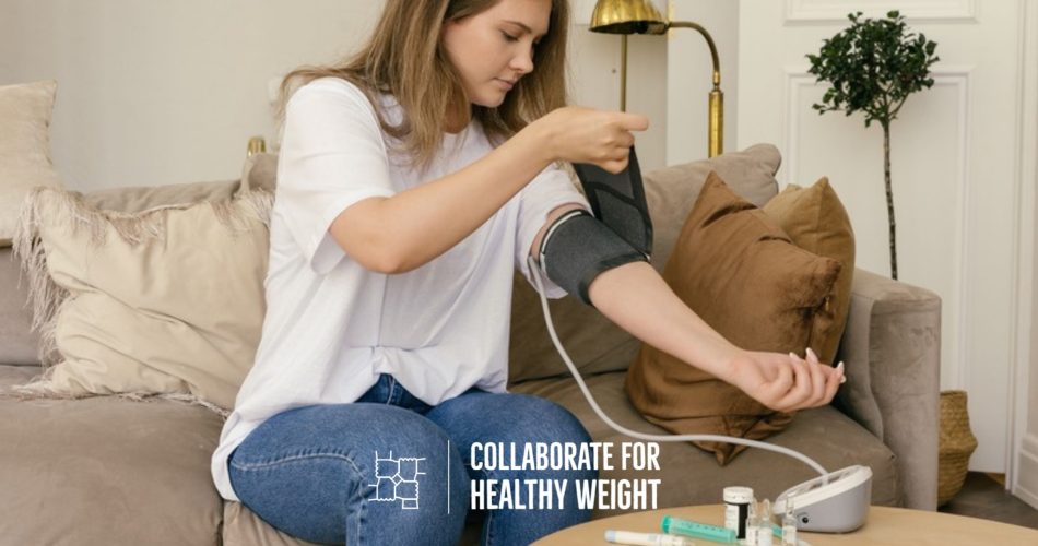 Person measuring blood pressure at home with a digital monitor