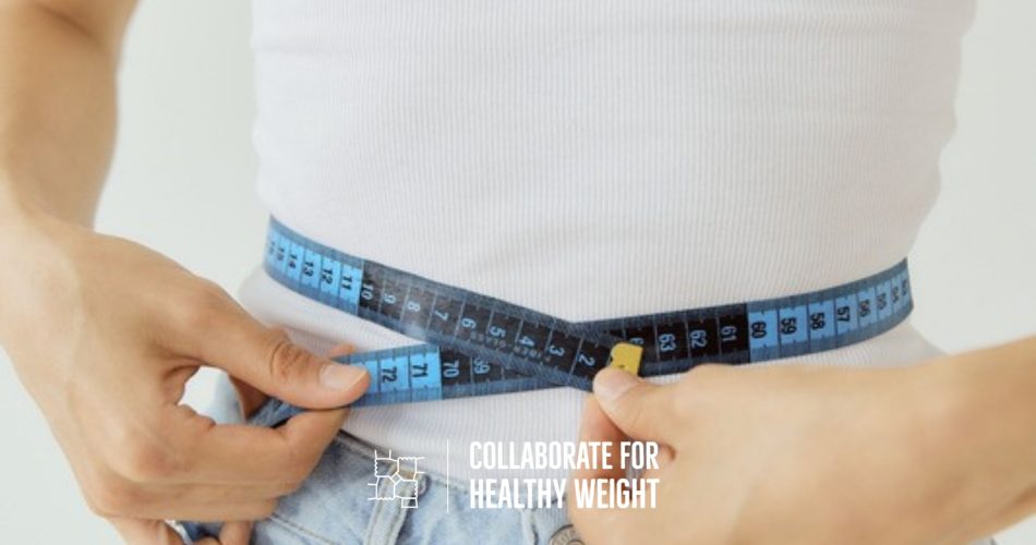 Woman measuring her waist with a tape measure to check normal waist size